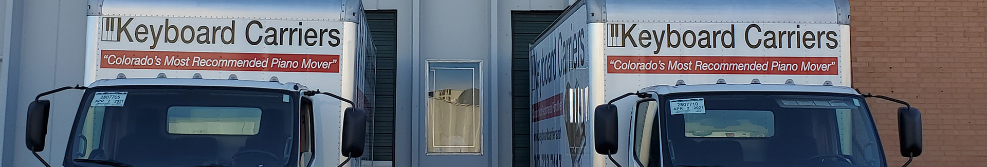 Wide photo of Keyboard Carriers trucks and warehouse frontage
